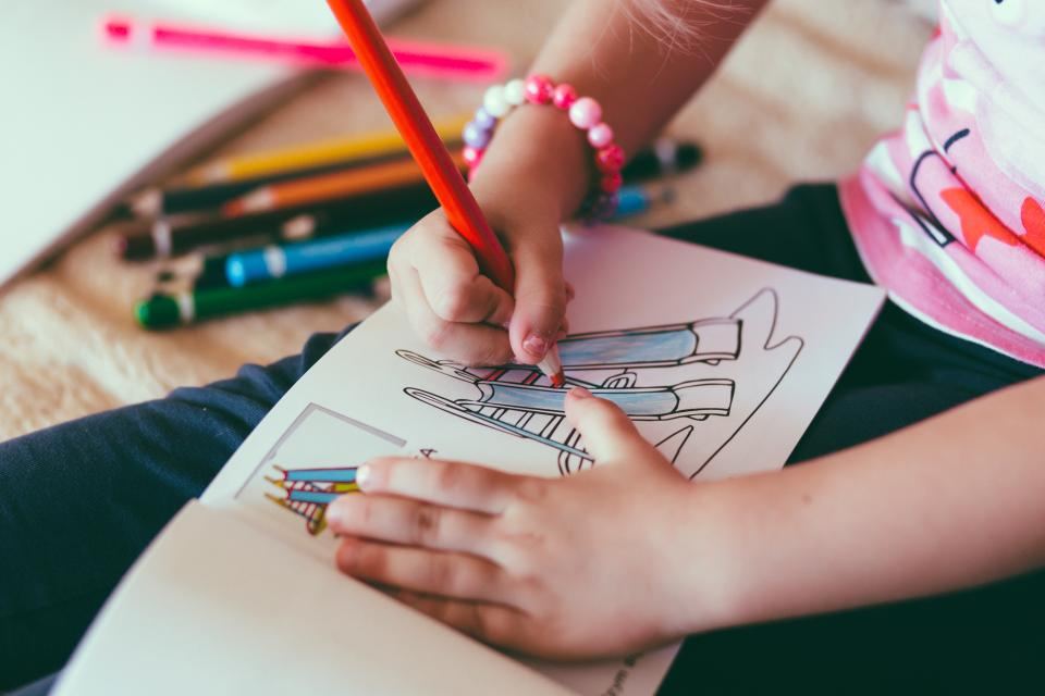 色鉛筆で塗り絵をする子どもの手元