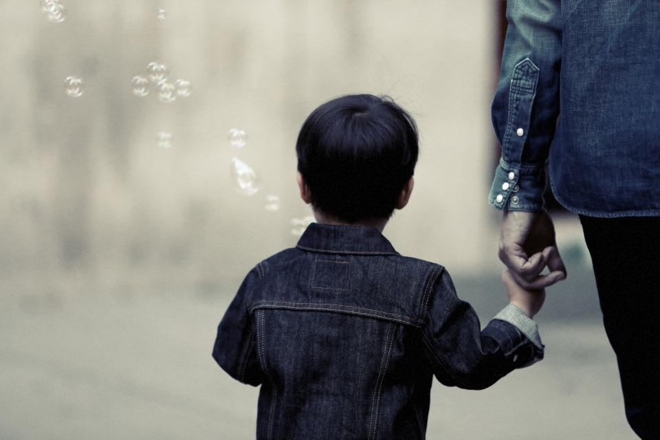 大人の手に手を伸ばす子ども